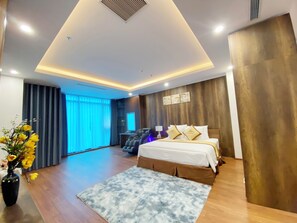 A modern hotel room with a large bed, a massage chair, a TV, and a view of the outdoors. - The King Hotel condotel Thai Nguyen (Thai Nguyen)