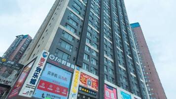 A high-rise building with multiple advertisements on its facade.