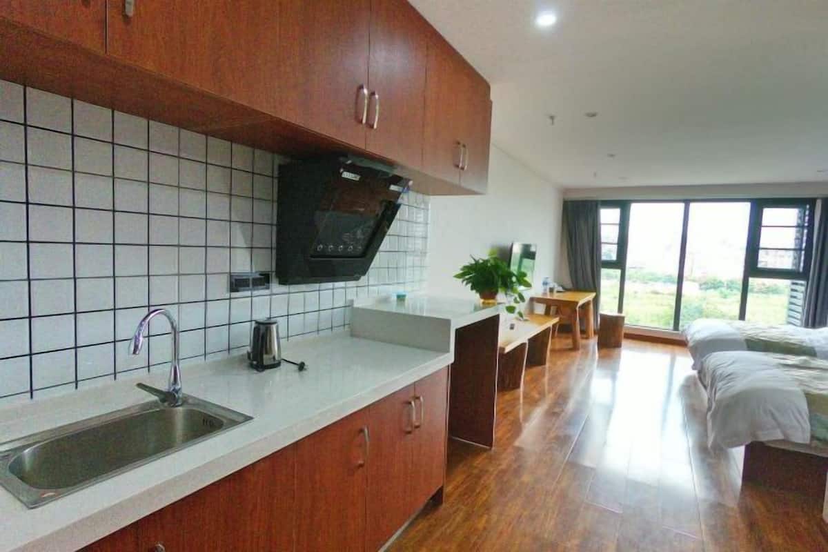 Uma cozinha moderna com forno embutido, pia e área de refeições com mesa e cadeiras.