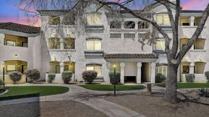 A multi-story building with a symmetrical facade, multiple windows, and a central entrance. - FREE GOLF! Resort Style 1st floor condo in Great Location! Heated Pool/Spa/Gym, Near Shops/Dining! (Scottsdale)