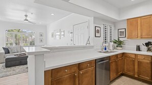 A modern kitchen with wooden cabinets, a stainless steel dishwasher, and a large island. - FREE GOLF! Resort Style 1st floor condo in Great Location! Heated Pool/Spa/Gym, Near Shops/Dining! (Scottsdale)