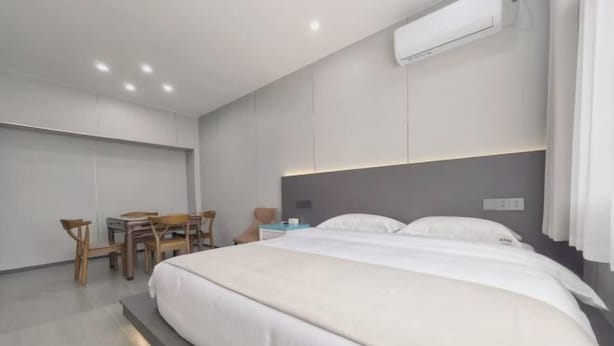 A modern hotel room with a large bed, a desk, and a chair. - Jiahe Homestay (Emeishan Tourism Passenger Transport Center Baoguosi Station) (Emeishan City)