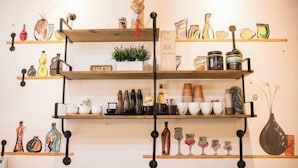 A wall-mounted shelf unit with various kitchenware and decorative items. - Jiahe Homestay (Emeishan Tourism Passenger Transport Center Baoguosi Station) (Emeishan City)