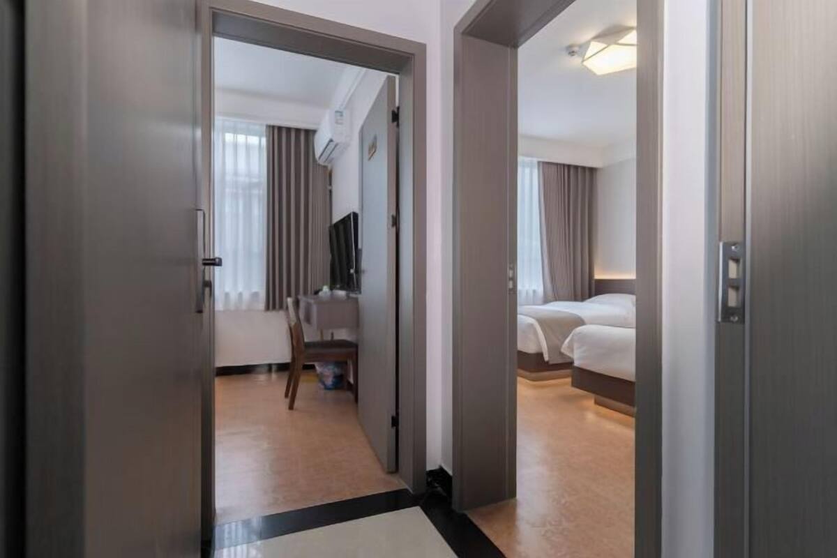 A hotel room with a bed, a desk, and a chair.