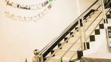 A staircase with a metal railing and a wall-mounted photo collage.