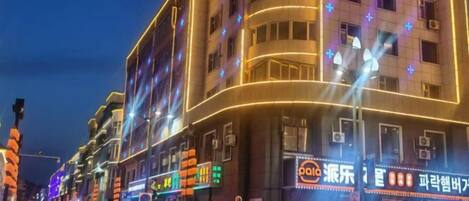A multi-story building with illuminated signage and a curved facade.