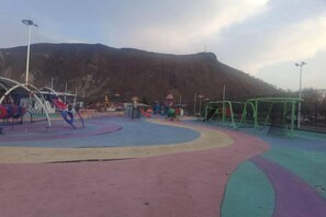A playground with various play structures and a mountain in the background. - Jiang Zhi Yuan Inn (Changbai County)