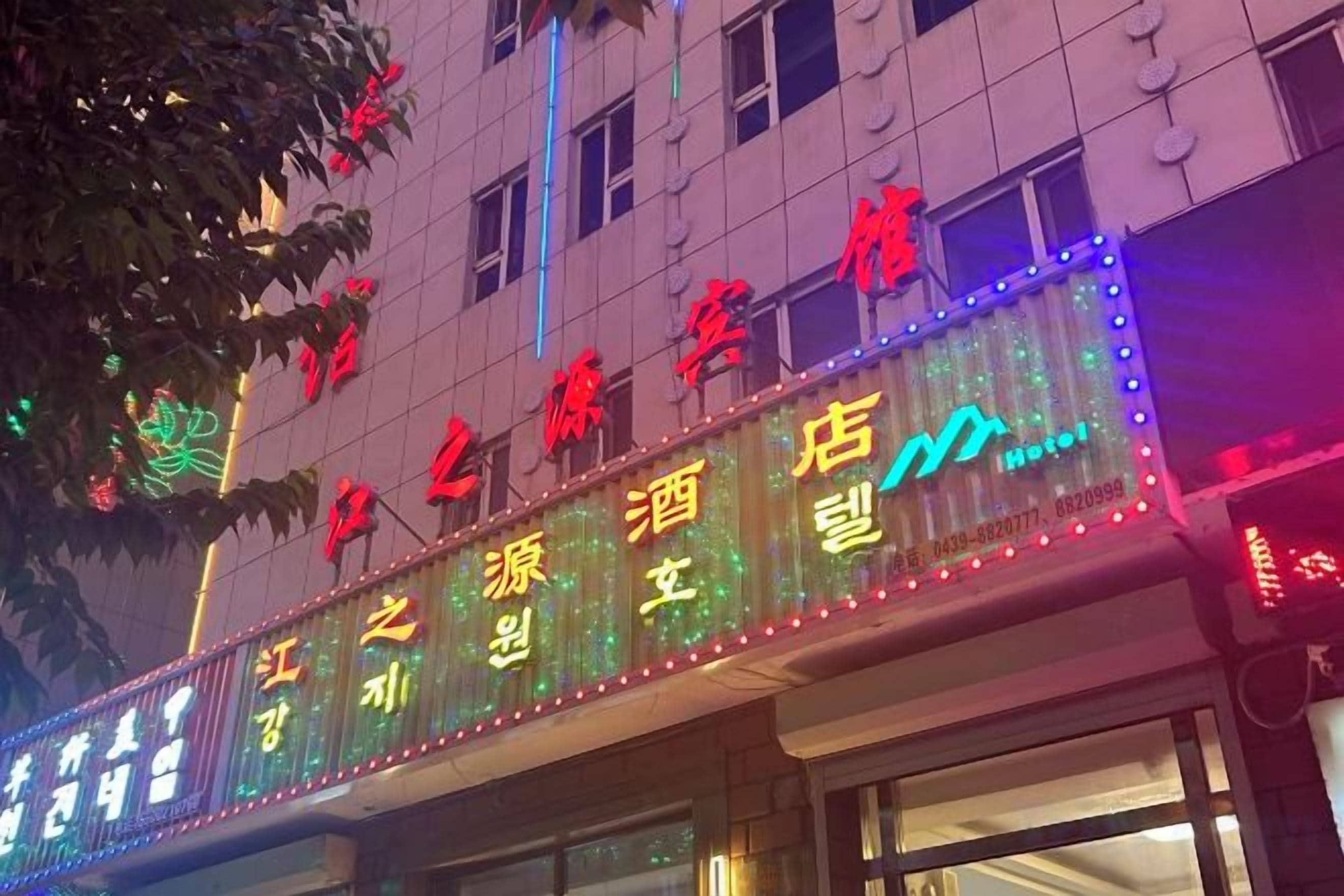 A hotel sign with illuminated text and a neon outline.