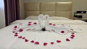 A hotel room with a bed, a headboard, and a nightstand with a lamp. - Jiang Zhi Yuan Inn (Changbai County)