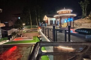 A gazebo with a circular roof and a railing, surrounded by a paved area with a small garden. - Ketianxia Hot Spring Resort (Longyan)