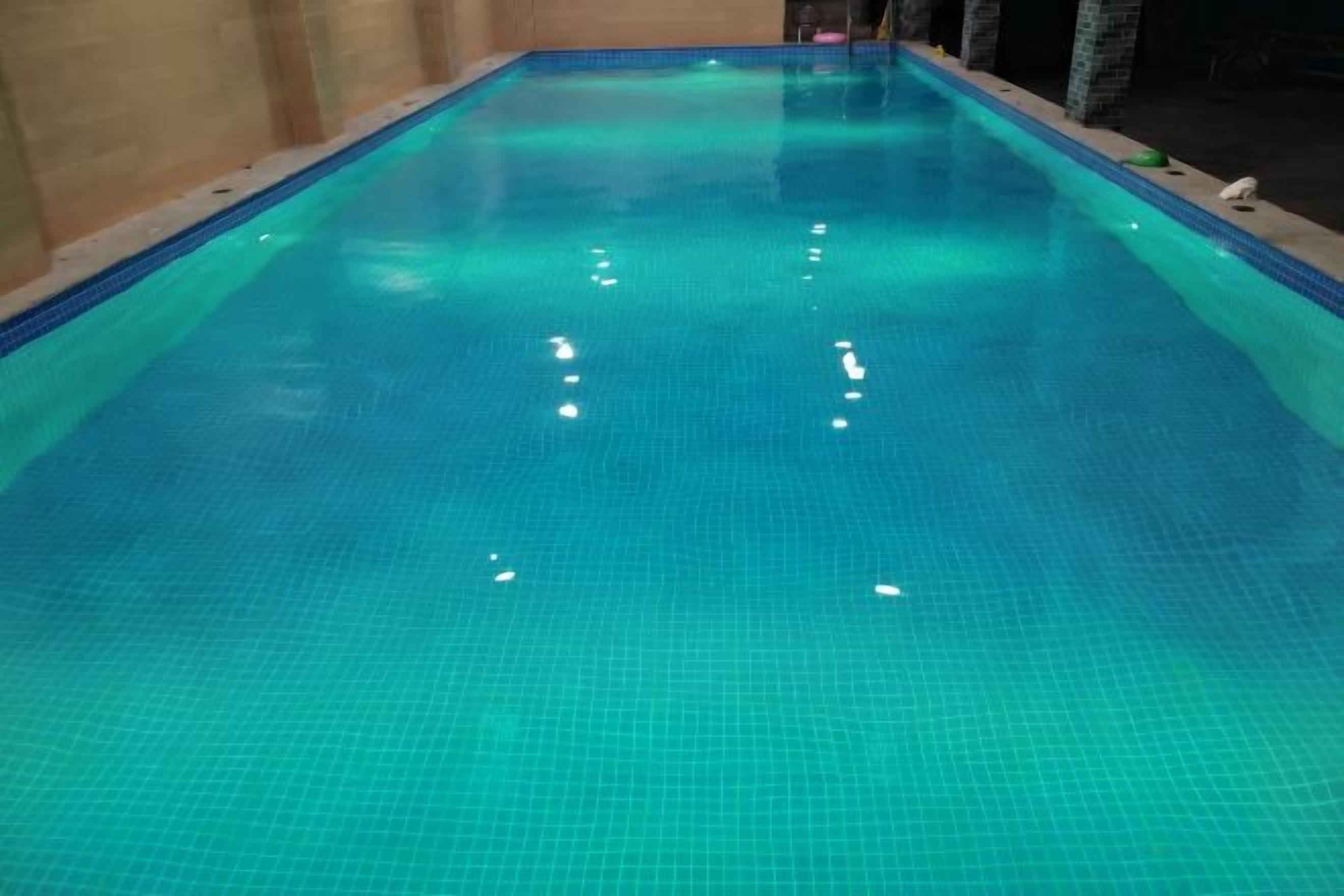 Una piscina interior cristalina con suelo y paredes de azulejos.