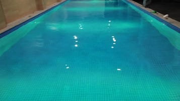 Una piscina interior cristalina con suelo y paredes de azulejos.