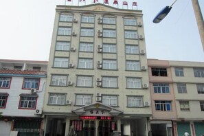 A multi-story hotel with a central entrance, air conditioning units, and a signboard. - Ketianxia Hot Spring Resort (Longyan)