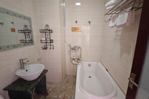 Un baño con lavamanos, bañera y un perchero para toallas.