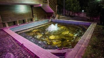 A hot tub with a tiled border and a wooden deck surrounding it.