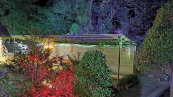 A building with a reflective surface, surrounded by trees and shrubs.