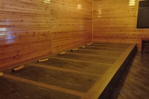Una habitación con paneles de madera, un largo banco de madera y una pequeña mesa.
