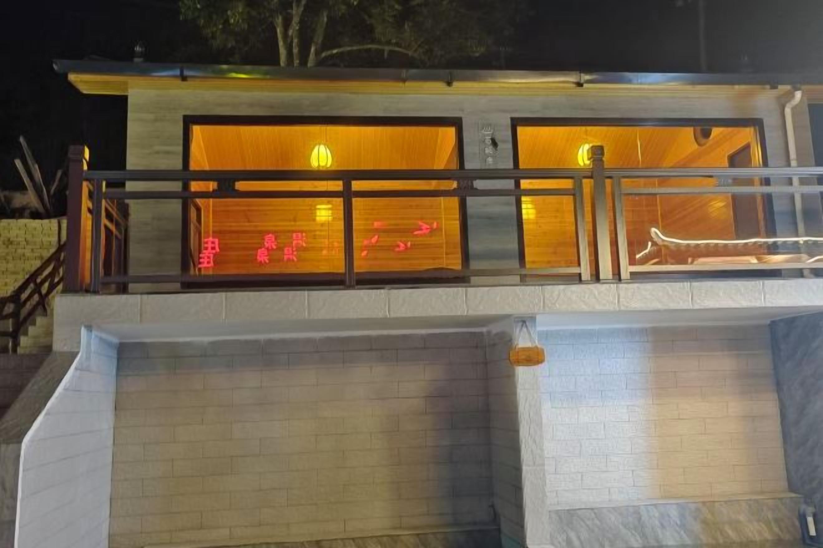 Un edificio moderno con fachada de vidrio, una escalera que conduce a un nivel superior y un área de piscina.