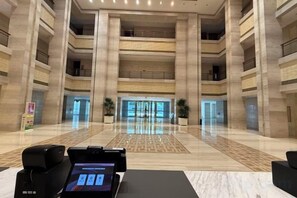 A spacious lobby with a marble floor, a reception desk, and a large glass entrance. - Petroleum Science & Technology Communication Center (Beijing)