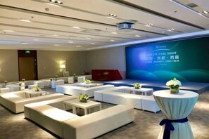 A hotel room with a large screen, multiple seating areas, and a stage. - Petroleum Science & Technology Communication Center (Beijing)