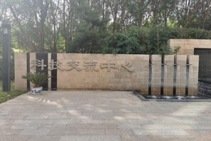 A stone wall with Chinese characters, a potted plant, and a water feature. - Petroleum Science & Technology Communication Center (Beijing)