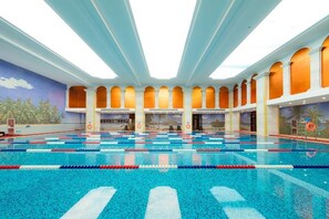 An indoor swimming pool with multiple lanes, a high ceiling, and a mural on the wall. - Petroleum Science & Technology Communication Center (Beijing)