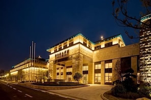 Un edificio moderno con una entrada destacada, ventanas amplias y fachada bien iluminada.