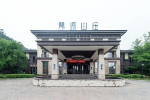 A modern building with a covered entrance, a signboard, and a landscaped area in front. - Nanchang Qinyuan Villa (Nanchang)