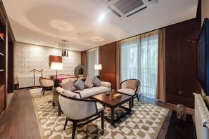 A modern hotel room with a sofa set, a coffee table, a fireplace, and a large window with curtains. - Nanchang Qinyuan Villa (Nanchang)