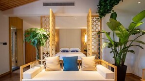 A bedroom with a bed, a wooden bench, and potted plants. - Zhangjiajie Wulingyuan Bamboo Holiday Homestay (Zhangjiajie)
