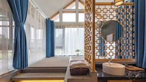 A modern bathroom with a large window, a wooden partition, a round mirror, and a marble countertop. - Zhangjiajie Wulingyuan Bamboo Holiday Homestay (Zhangjiajie)