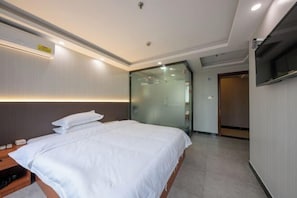 A hotel room with a bed, bedside table, and a TV mounted on the wall. - Shenzhen Haoyoulai Hotel (Dongmen Pedestrian Street Hubei Subway Station) (Shenzhen)