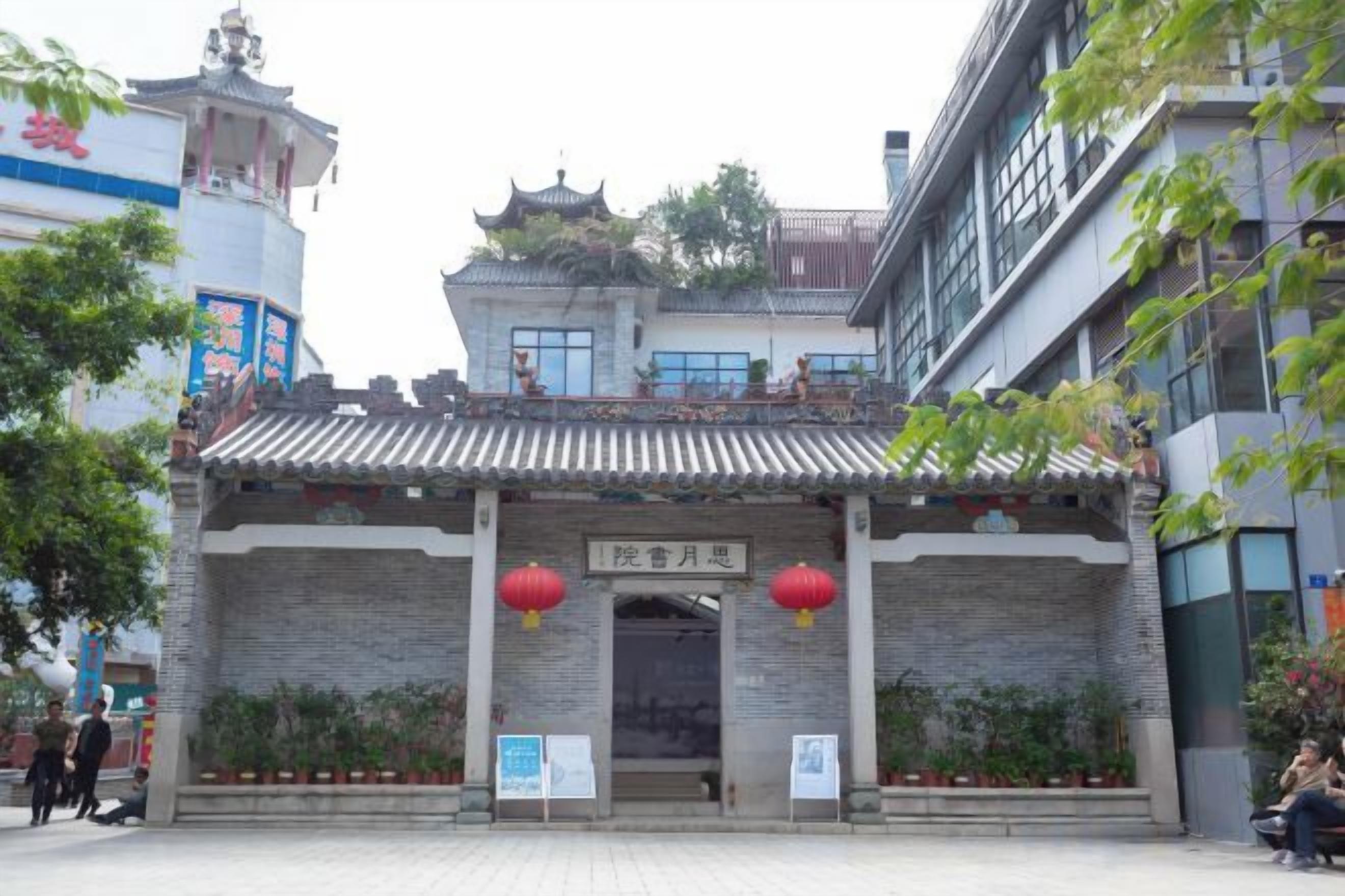 A traditional building with a tiled roof and an entrance with two red lanterns.