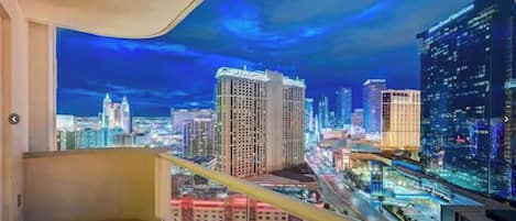 Un rascacielos con vista panorámica de la ciudad de noche, con imponentes rascacielos iluminados y una autopista con mucho tráfico.