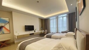 A hotel room with two beds, a TV, a desk, and a large window. - Qinheyuan Linxuan Holiday Hotel (Haining)