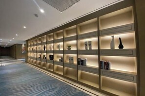 A hallway with a series of illuminated shelves displaying various items. - Qinheyuan Linxuan Holiday Hotel (Haining)