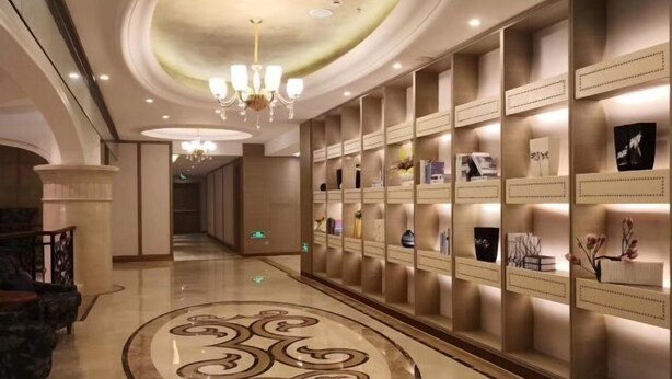 A hotel corridor with a marble floor, a chandelier, and a wall with display cases. - Qinheyuan Linxuan Holiday Hotel (Haining)