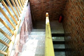 A staircase with a yellow handrail, wooden railings, and a brick wall. - Huangqunliang Farmhouse (Danjiangkou)
