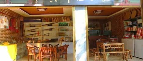 Une devanture de magasin avec une enseigne, des meubles en bois et des étagères remplies de marchandises.