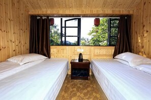 A room with two beds, a window with curtains, and a small table with a lamp. - Huangqunliang Farmhouse (Danjiangkou)