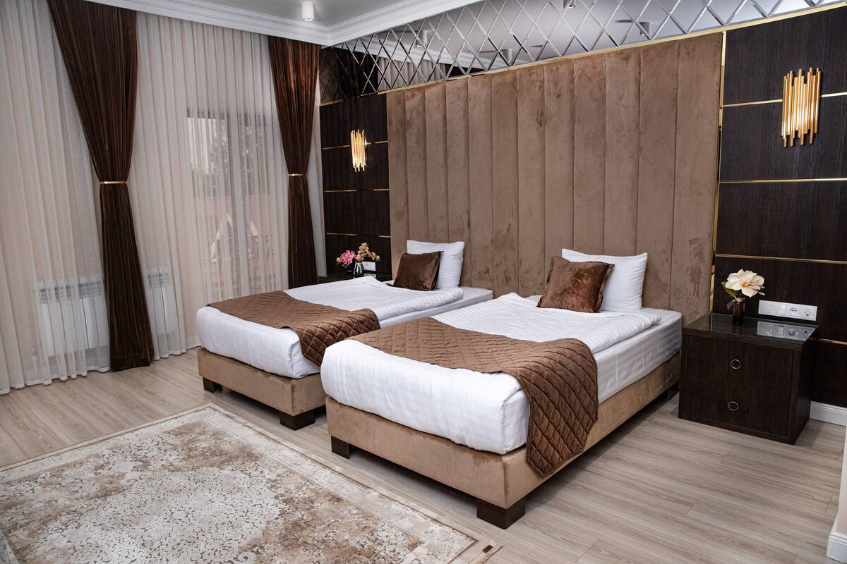 A double bed room with a wooden headboard, a nightstand, and a bedside table.