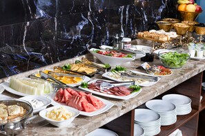 A buffet with various food items and utensils. - MAROKAND SPA HOTEL (Samarkand)