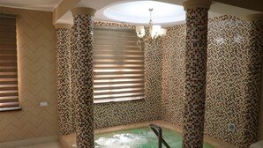 Un cuarto de spa con pared de mosaicos, una bañera y un aplique de techo.