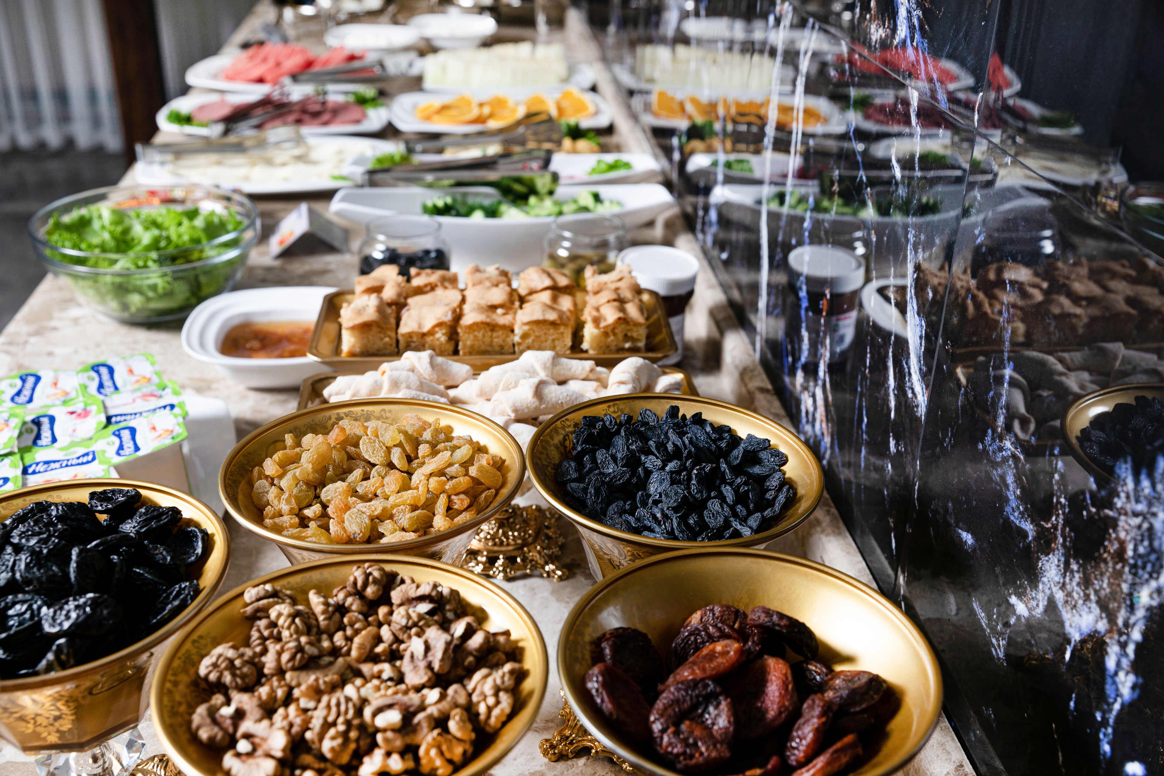 A buffet table with various food items including fruits, nuts, and pastries.