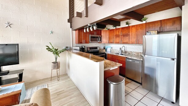 Una cocina moderna con armarios de madera, electrodomésticos de acero inoxidable y una pequeña isla.