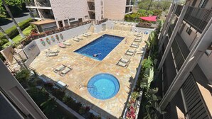 Una piscina en la azotea con sillones de descanso y una pequeña zona de piscina.