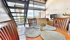 Un comedor con una mesa de madera, sillas y vistas al exterior.