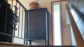 Una escalera con barandal de madera oscura y rellano alfombrado.