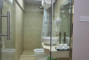 A bathroom with a glass shower enclosure, a white sink with a bowl, and a toilet. - Buding Inn (Yi County)