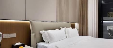 A hotel room with a bed, a nightstand with a lamp, and a window with curtains.